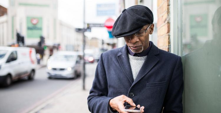 Man leaning against a wall on his mobile phone