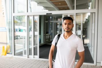 young man waiting outside of a hospital