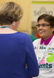 Woman wearing Healthwatch clothing talking to another woman 